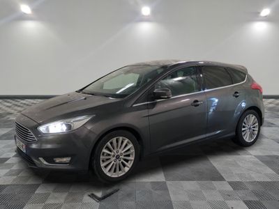 La voiture grise est garée dans le garage, sur le sol à damier.