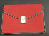 an image of a red purse with a metal clasp on a black surface