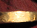 une personne tenant une bague en or dans laquelle est enfoncé un couteau
