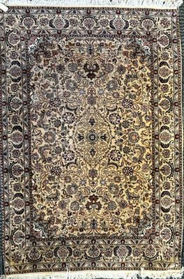 un tapis persan ancien avec un motif floral et des franges