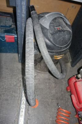 une image représentant un aspirateur et un tuyau dans une pièce