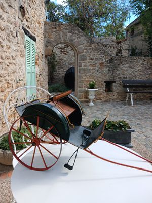 une calèche posée sur une table devant un bâtiment en pierre
