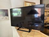 a flat screen tv sitting on a counter in a kitchen