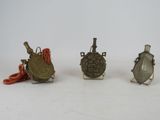 three small metal objects sitting on top of a white surface