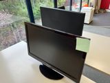 a computer monitor sitting on top of a desk