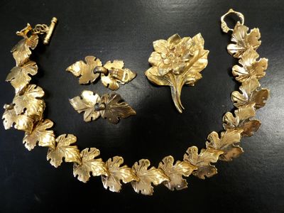 an image of a gold necklace and earring set on a black surface
