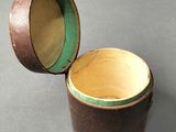 a small wooden box with a green lid on a table