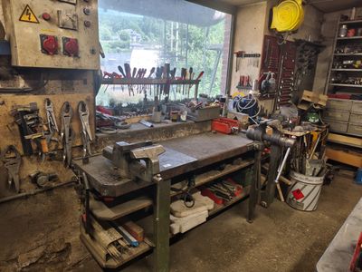 un établi dans un garage, sur lequel sont posés de nombreux outils