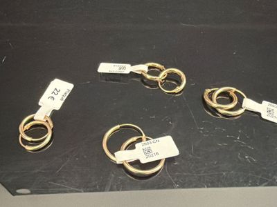 cinq paires de ciseaux dorés posés sur une surface noire