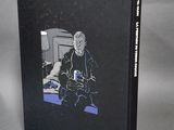 a black book with a picture of a man sitting in a chair