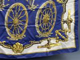 une image représentant une écharpe bleue et dorée ornée d'une roue de la fortune