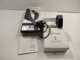 a box with a watch and a charger sitting on a bed