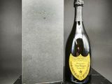 une bouteille de champagne posée sur une table à côté d'un coffret