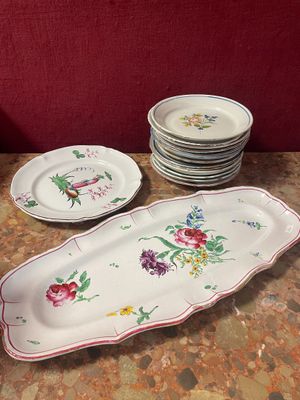 many plates and bowls on the table with a red wall in the background