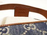 a close up of a blue and white bag with a brown strap