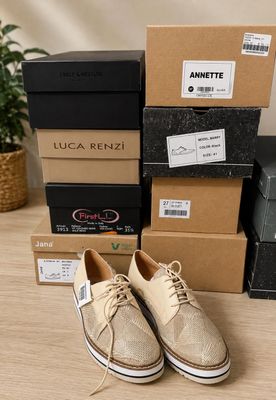 une photo d'une paire de chaussures beiges posées sur des cartons