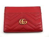un gros plan d'un portefeuille rouge orné d'un logo GG doré