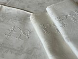 three napkins with embroidered designs on them on a table