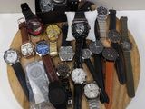 a lot of watches that are sitting on a wooden plate
