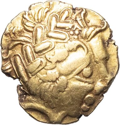 gros plan d'une pièce d'or sur une surface blanche