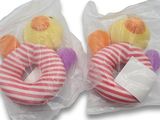 deux peluches emballées dans des sacs en plastique, posées sur une surface blanche