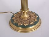a gold and green lamp on a table with a white background