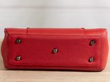 a red purse sitting on top of a wooden table