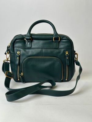 a green leather handbag on a white background