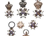 several different types of medals are displayed on a white surface