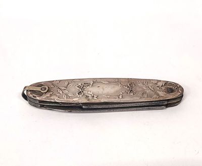 un petit couteau posé sur une surface blanche