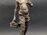 bronze statue of a boy with a bucket and a hat