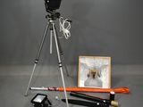 a tripod with a camera and other items on the floor