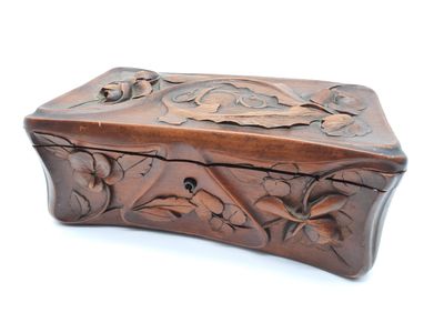 boîte en bois sculptée, ornée de fleurs et de feuilles sur un fond blanc