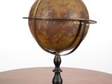 un petit globe posé sur une table en bois
