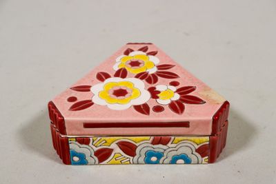 une petite boîte rose décorée de fleurs, posée sur une table