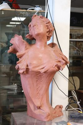 a statue of a woman holding a bird in a glass case