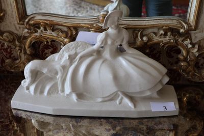 a statue of a woman sitting on a table in front of a mirror