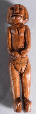une figurine en bois représentant un homme assis sur une table