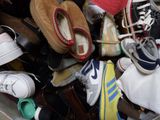 many pairs of shoes that are sitting in a bin