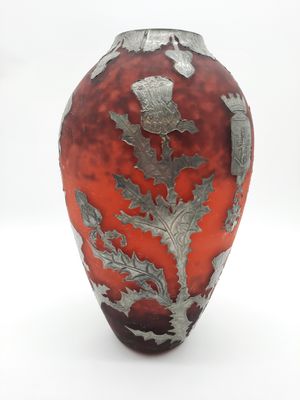 un vase rouge orné d'un motif argenté