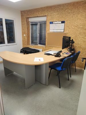 un bureau avec un ordinateur et une chaise dans la chambre