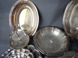 a lot of silver dishes and pans on the table
