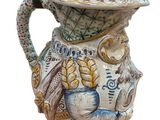 a ceramic pitcher with a hat on top of it