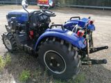 a blue tractor that is parked on the side of the road
