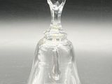 a glass bell on a table with a black background