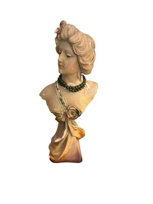 une statue représentant une femme avec une fleur sur la tête