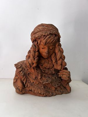 statue d'une femme aux cheveux longs assise sur une surface blanche