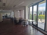une pièce équipée de tables et de chaises, avec vue sur la ville