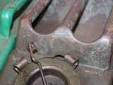 a close up of a metal object with a green handle