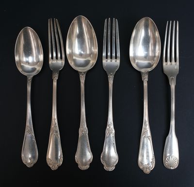 six cuillères et six fourchettes sont alignées sur une surface noire